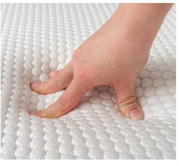 Hand pressing into a textured mattress surface